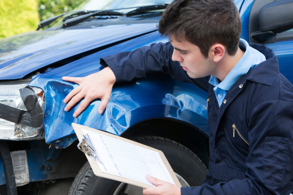 man with damaged blue truck